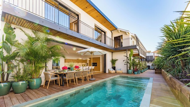 A modern building with a pool, outdoor seating, and potted plants. - Villa Émeraude: A stunning villa located 150 meters from the beach. (Arcachon)