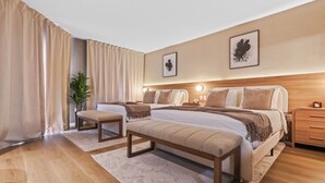 A modern hotel room with two beds, a bench, a bedside table, a nightstand, and a potted plant. - Studio near Universal, Epic & I-Drive (Orlando)