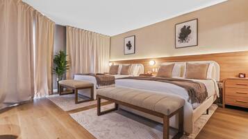 Ein modernes Hotelzimmer mit zwei Betten, einer Bank, einem Nachttisch und einer Topfpflanze.