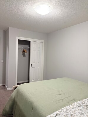 Ein Schlafzimmer mit Bett, Schrank und Tür.