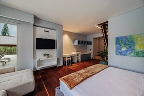 Ein modernes Schlafzimmer mit einem großen Bett, einem an der Wand montierten Fernseher, einem Schreibtisch und einem Sessel.