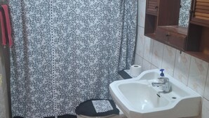Ein Badezimmer mit Toilette, Waschbecken und Duschvorhang.