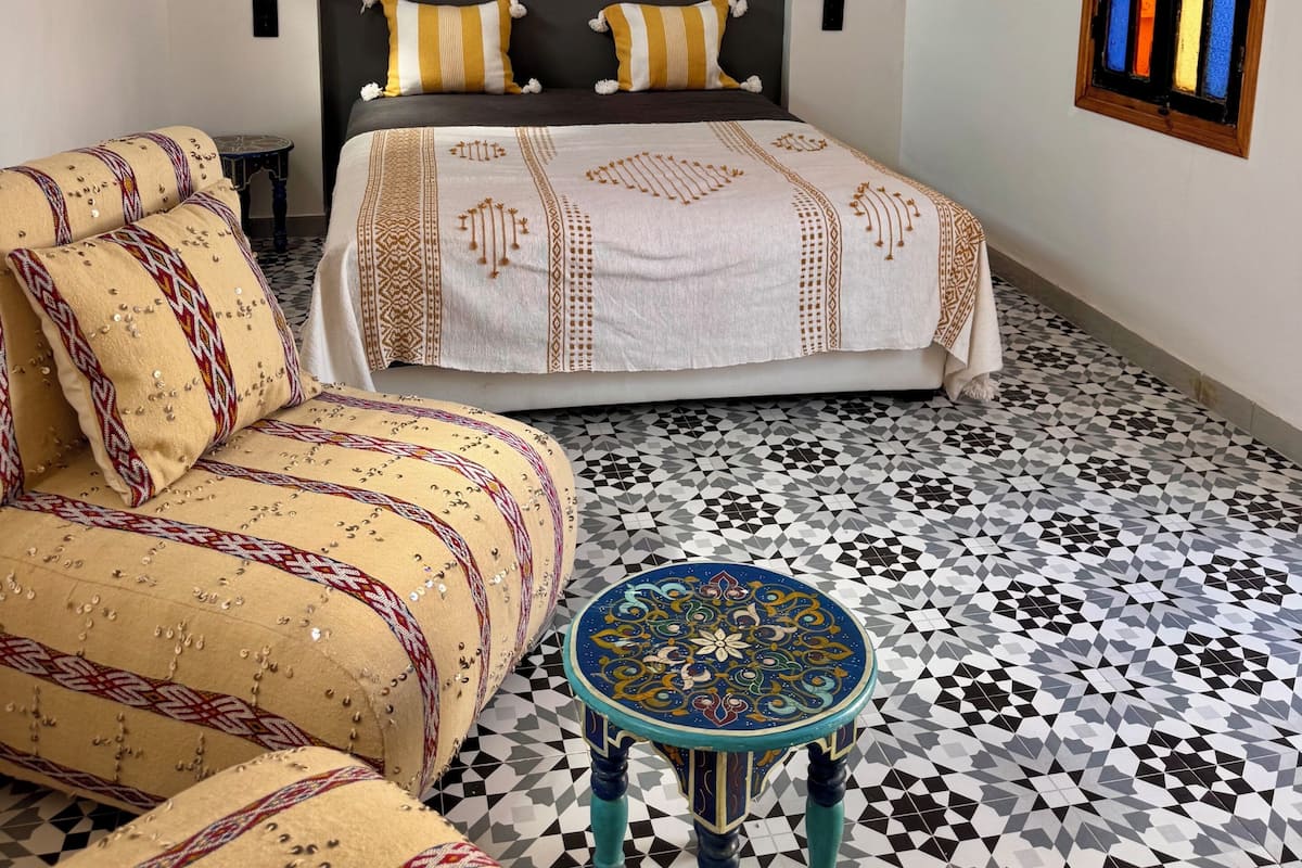 Ein Schlafzimmer mit einem Bett, einem Sofa und einem kleinen Tisch.