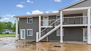 A two-story building with a staircase, a garage, and a covered area.