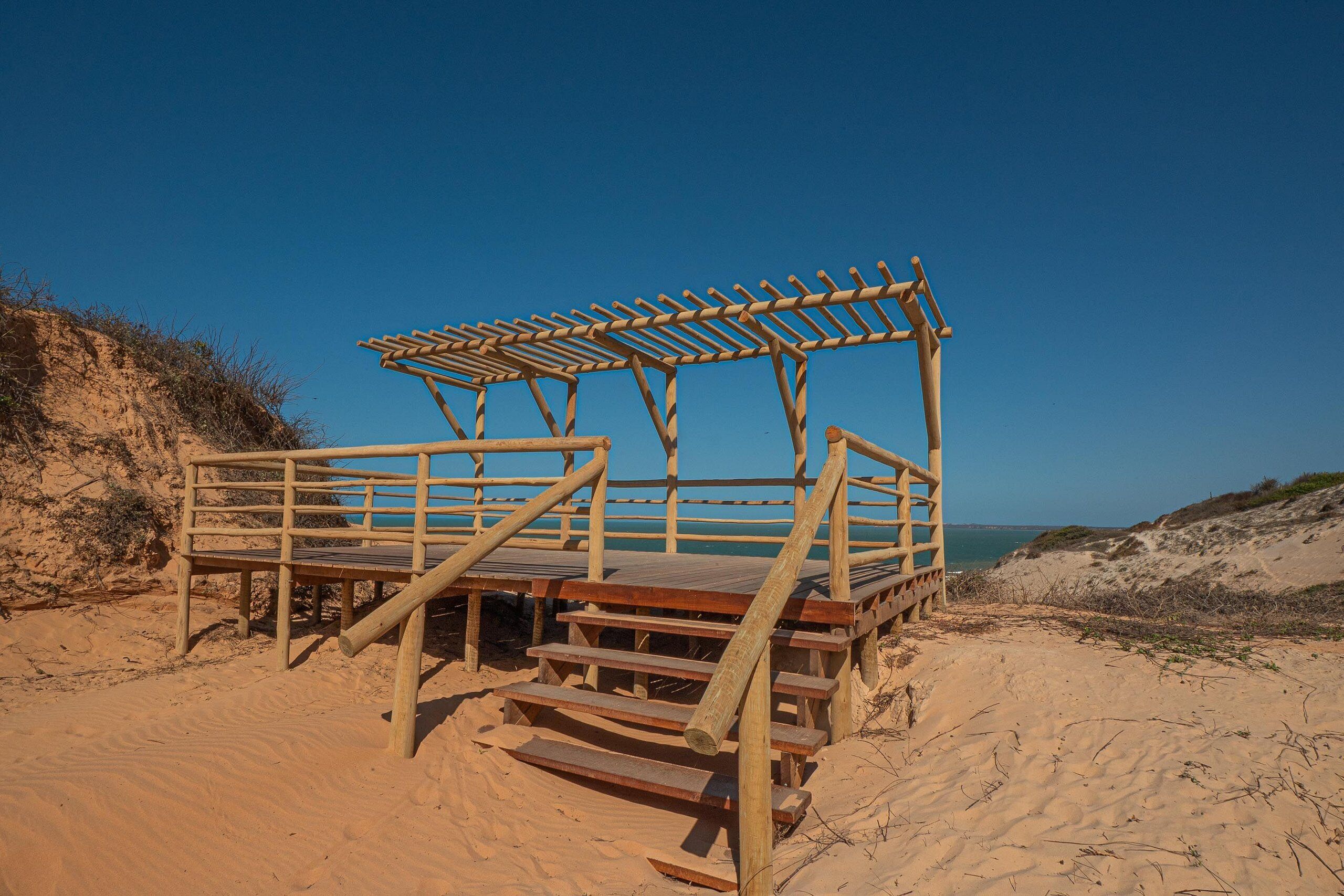 A wooden beach structure with steps leading to a platform.