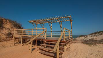 A wooden beach structure with steps leading to a platform.