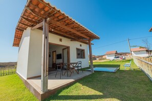 Einbungalow mit Terrasse, Swimmingpool und umzäunter Garten.