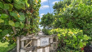 A wooden gate with a sign reading 'Private Property No Trespassing.' - Luxurious Retreat At The Whispering Palms (Wabasso Beach)