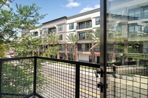 A modern building with multiple floors, a balcony, and a view of the street.