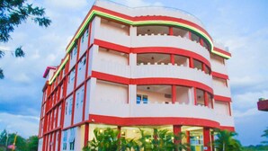 Un edificio de varios pisos con balcones, ventanas amplias y una entrada central.