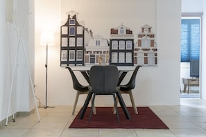 A dining area with a table, chairs, and a red rug.