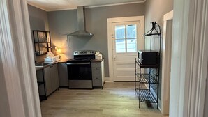 Une cuisine équipée d’une cuisinière, d’un four et d’une fenêtre.