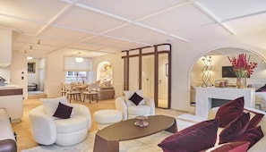 A spacious living area with a sofa, armchairs, a coffee table, and a fireplace. - EXPERIENCE PARISIAN ELEGANCE, LOCATED IN BETWEEN INVALIDES & SAINT-GERMAIN (Paris)