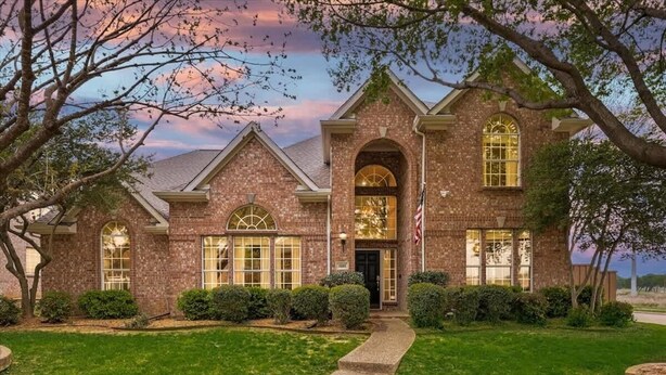 A brick house with a front entrance, a driveway, and a well-maintained lawn. - Grand Gem for Large Groups: Pool, Cinema, Playroom (Carrollton)