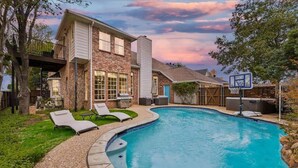 A swimming pool with lounge chairs, a basketball hoop, and a house with a brick facade. - Grand Gem for Large Groups: Pool, Cinema, Playroom (Carrollton)
