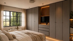 Une chambre à coucher avec un lit, une commode, un téléviseur et une fenêtre donnant sur un paysage verdoyant.