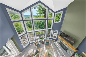 A room with large windows, a fireplace, and a view of the outdoors. - Stunning 5 Bed 3 Bath-Golf Simulator-2 Hot Tubs-2 Fire Pits-Theater (Bellaire)