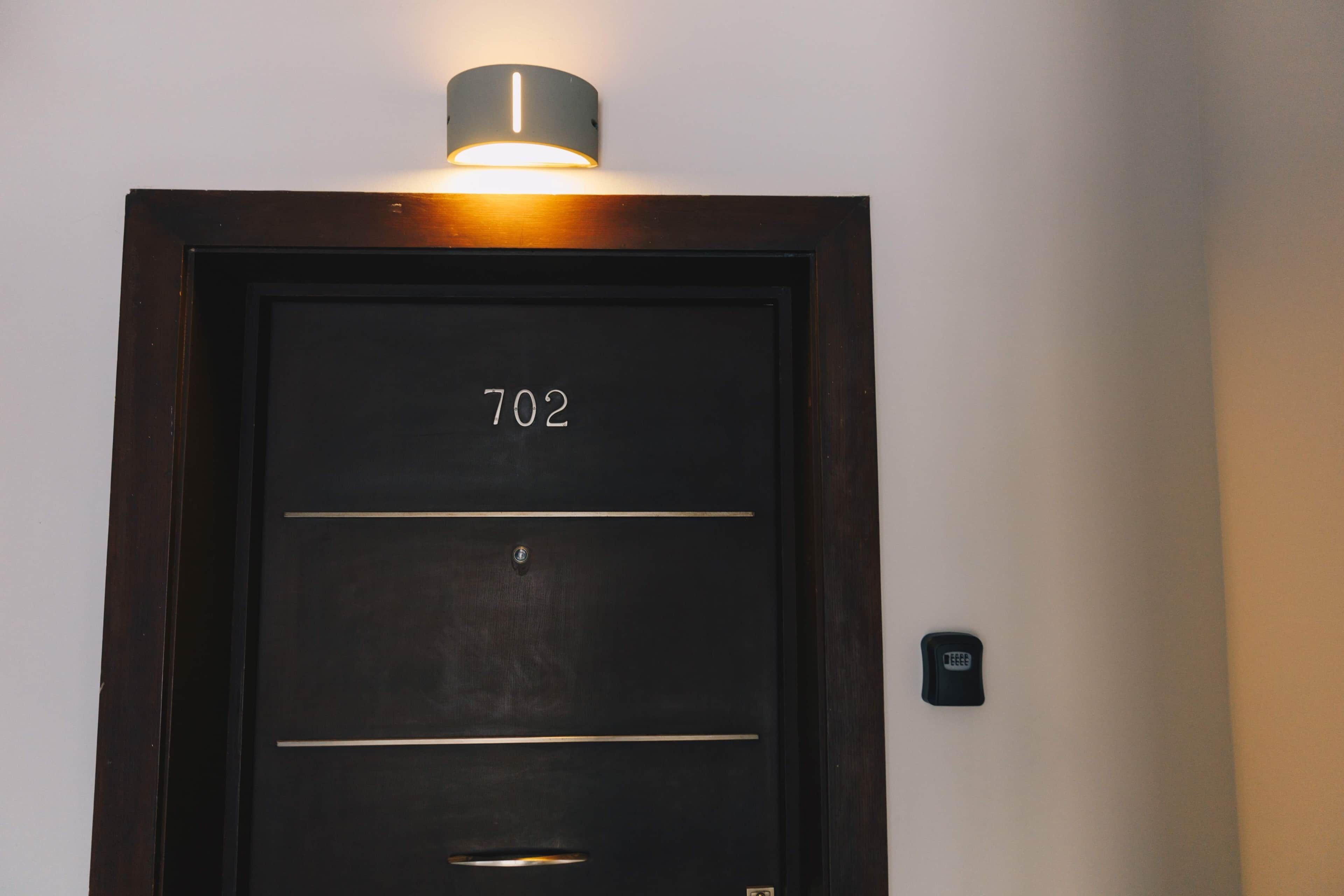 Une porte portant le numéro 702, un trou de serrure et un clavier pour ouvrir la porte.