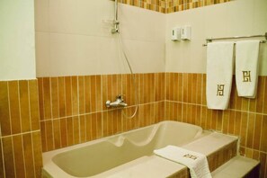 A bathroom with a bathtub, a shower, and two towels hanging on a rack. - Maple and Moon Suite - Comfort & Elegance Stay 5 (New Cairo City)