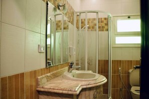 A bathroom with a marble sink, a glass shower enclosure, and a mirror. - Maple and Moon Suite - Comfort & Elegance Stay 5 (New Cairo City)