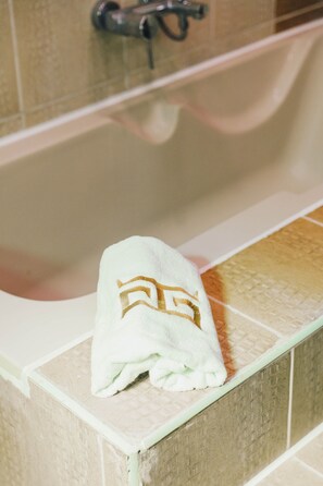 Ein weißes Handtuch mit goldener Kennzeichnung auf einem Badezimmerwaschtisch.