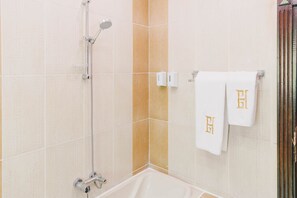 Ein Badezimmer mit Dusche, Badewanne und zwei Handtüchern mit einem Monogramm.