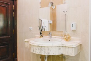A bathroom with a marble sink, a mirror, a towel dispenser, and a soap dispenser. - Maple and Moon Suite - Comfort & Elegance Stay 3 (New Cairo City)