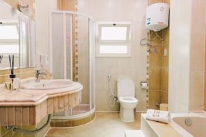Ein Badezimmer mit Duschkabine, Toilette, Waschbecken mit Waschtisch und Badewanne.
