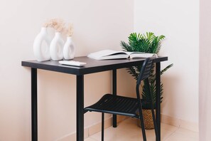 A desk with three white vases, an open book, and a potted plant. - VIOLA Brand New Studio - 26 (New Cairo City)