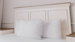 Ein Bett mit weißer Bettwäsche und einem Holzkopfende.