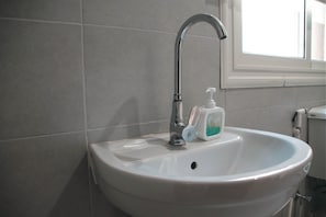 Ein Waschbecken mit Wasserhahn und Seifenspender.