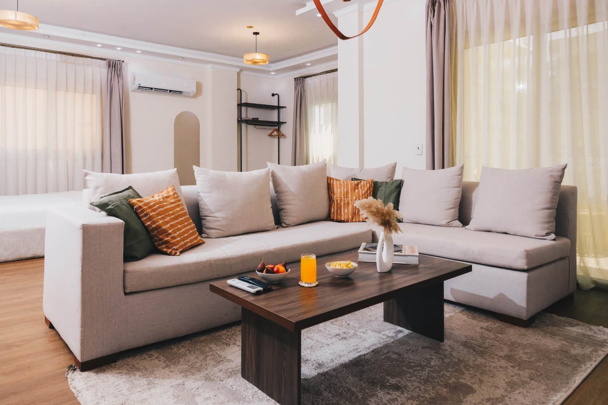 A modern living room with a sofa set, a coffee table, and a hanging light fixture.