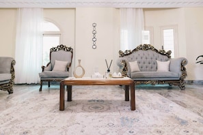 A room with two ornate sofas, a wooden coffee table, and a patterned carpet. - Maple and Moon Suite - Comfort & Elegance Stay 6 (New Cairo City)