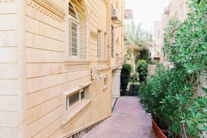 A narrow alleyway between buildings with a small window and a door. - Maple and Moon Suite - Comfort & Elegance Stay 6 (New Cairo City)