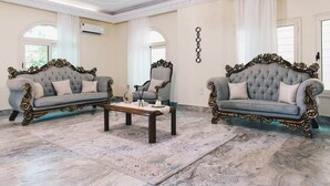 A spacious room with two ornate sofas, a central coffee table, and a patterned rug. - Maple and Moon Suite - Comfort & Elegance Stay 6 (New Cairo City)