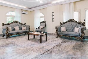 A spacious room with two ornate sofas, a central coffee table, and a patterned rug. - Maple and Moon Suite - Comfort & Elegance Stay 6 (New Cairo City)
