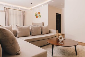 Ein modernes Wohnzimmer mit einer Couch, einem Couchtisch und einer dekorativen Vase.