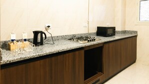 Una cocina con encimera de granito, estufa negra, microondas y cafetera.