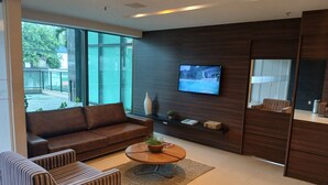 Una sala moderna con un sofá, una mesita de centro, un televisor y una planta pequeña.