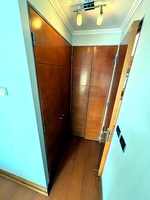 Un pasillo estrecho con paneles de madera y suelo de madera.