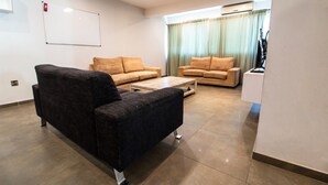 Ein Wohnzimmer mit zwei Sofas, einem Couchtisch und einer Tafel an der Wand.