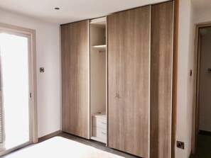 A room with a sliding wardrobe, a visible closet with hanging space, and a door leading to another room. - Central Luxurious 2 bedroom flat (Nicosia)