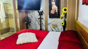 A hotel room with a bed, a TV, a picture, and a fan. - Cozy apartment in Itagüí | Wi-Fi | 2 bathrooms | Near Medellín (Itagüí)