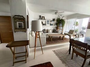 Ein Wohnzimmer mit Sofa, Couchtisch, Lampe und Deckenventilator.