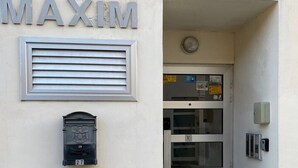 Ein Gebäudeeingang, über der Tür steht das Schild 'MAXIM'.