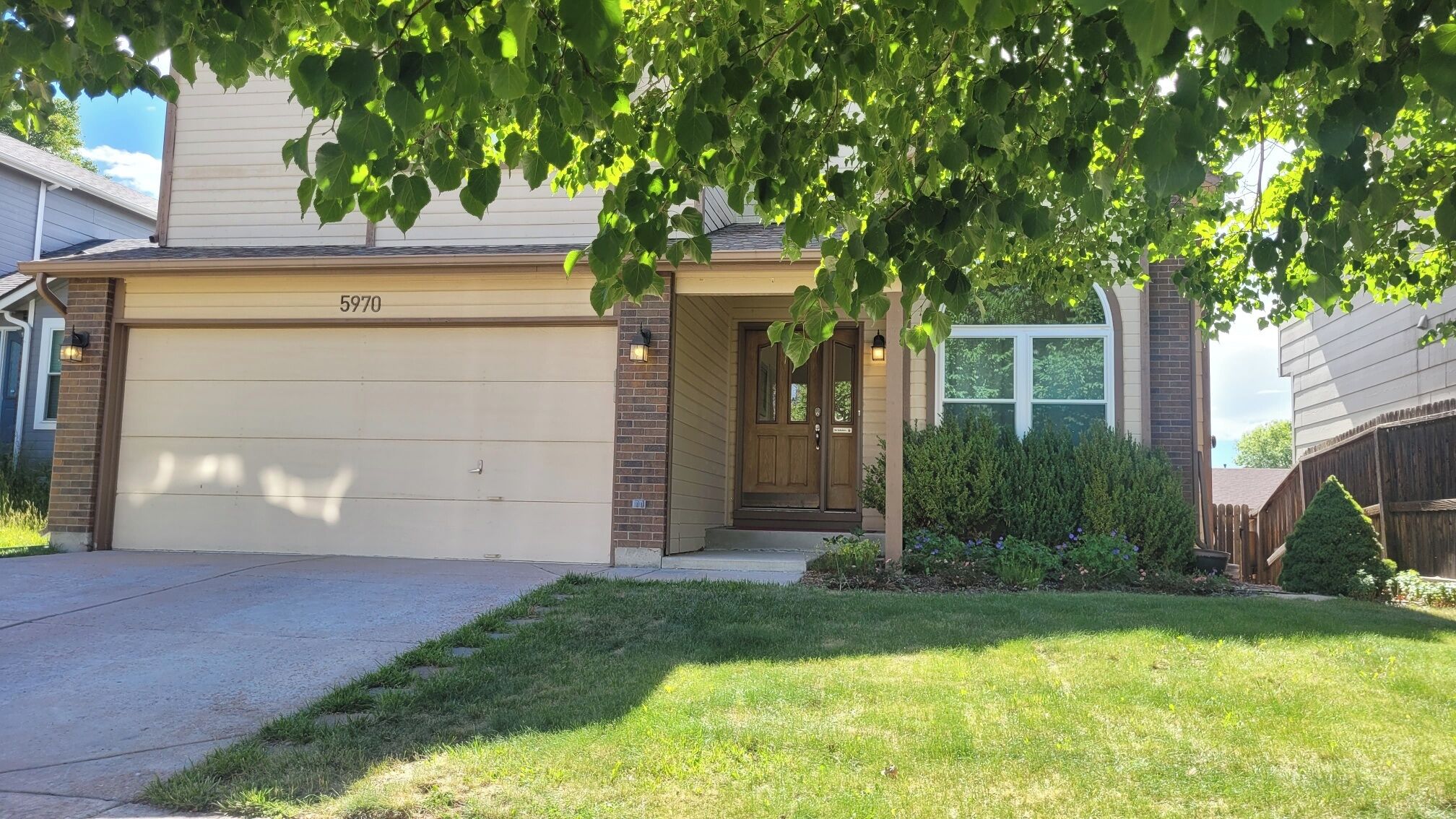 A residential house with a garage, a front door, and a well-maintained lawn.