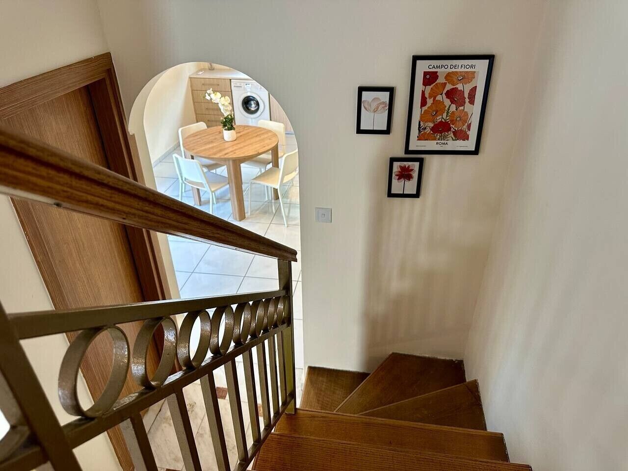 Eine Treppe mit Holzwurf und Blick auf einen Essbereich mit Stühlen und einem Tisch.