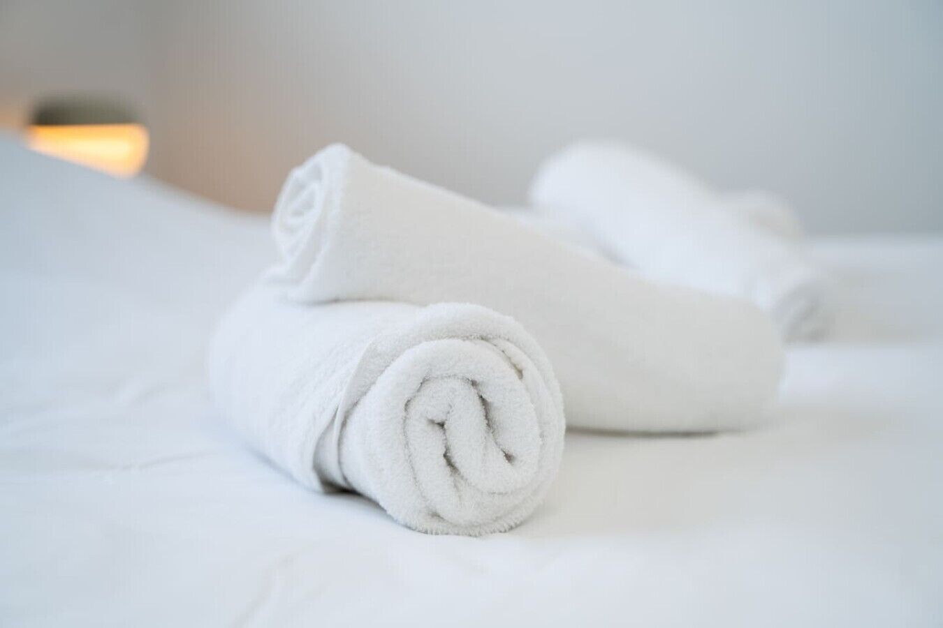Una toalla blanca doblada con cuidado sobre una cama.