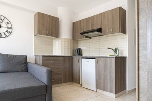 Una cuina moderna amb armaris de fusta, rentaplats integrat i un rellotge de paret.