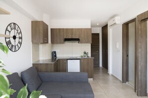 Una cuina moderna amb armaris de fusta, rentaplats integrat i cafetera.